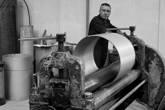 a sheet metal worker fabricating a metal tube